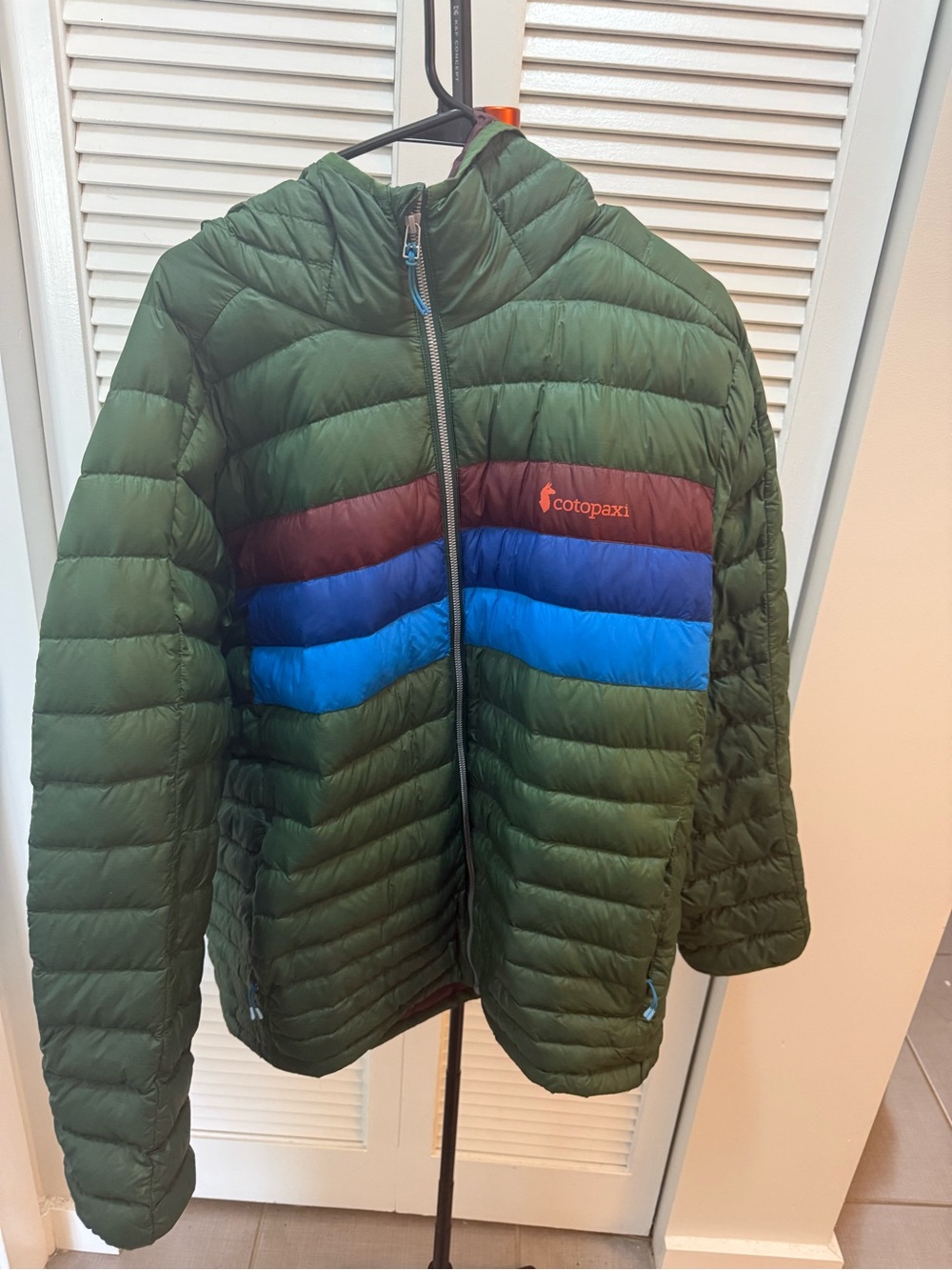 cotopaxi Green Puffer Jacket with Blue and Maroon Stripes
